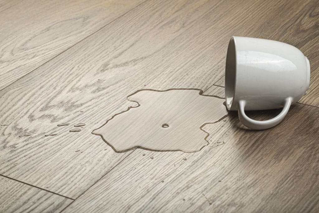 פרקט עם כוס מים שנשפכו עליו